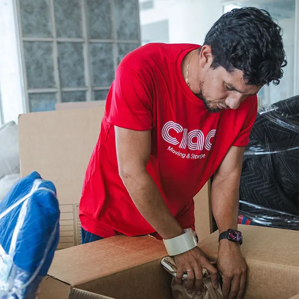 Ciao mover in red Ciao shirt packing a box
