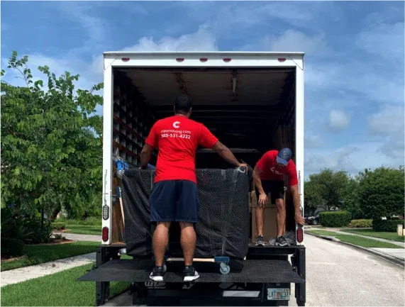 Ciao movers in red company shirts loading furniture onto the truck