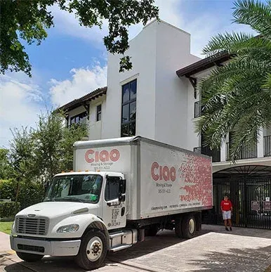Ciao Moving & Storage truck parked at a white Miami townhome